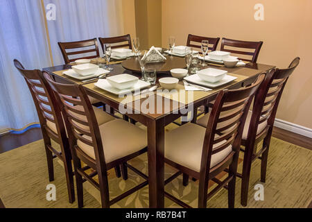 Dining room with set table and chairs Stock Photo