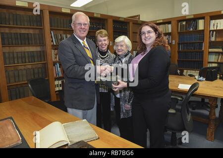 NEWPORT, R.I. (Dec. 1, 2016) Dara Baker (front right), head archivist for the Naval Historical Collection (NHC) at U.S. Naval War College (NWC) in Newport, Rhode Island accepts a donation from Duncan and Jeanne Ingraham (back left), MaryAnn (Ingraham) Brenner (back right), and Anne Hopkins (not pictured), family of U.S. Navy and Confederate navy officer Duncan Nathaniel Ingraham. The Ingraham family donated papers to NWC’s NHC that include three previously unknown manuscripts of historical significance, including a manuscript from Ingraham detailing the cruise of the U.S. Civil War Confederate Stock Photo