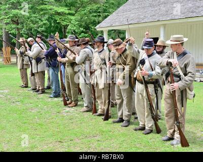 American Civil War reenactment soldiers in Confederate and Union uniforms stand in formation at battle recreation in Marbury Alabama USA. Stock Photo