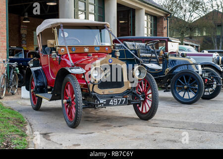 Line of Vintage cars outside a garage at Bicester Heritage centre. Bicester, Oxfordshire, England Stock Photo