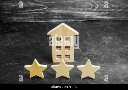 Three wooden stars and a house. Three star hotel or restaurant. Review of the critic. Quality of service and level of service. Rating of houses and pr Stock Photo