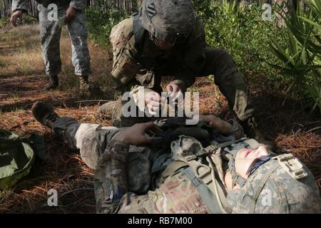 Soldiers assigned to the 5th Squadron, 7th Cavalry Regiment on Fort Stewart, treat a casualty during the Squadron's Spur Ride Dec. 6. Soldiers perform physical and mental tasks, such as disassembling and reassembling weapons, a ruck march, and land navigation, to earn their spurs.