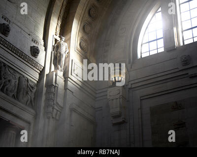 A ray of sun illuminating a marble statue of the main hall, antique Sala della Biglietteria, of the Milano Centrale train station. Milan, Italy. Stock Photo