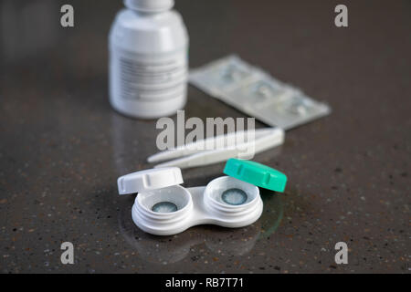 Container with green contact lenses on white background Stock Photo