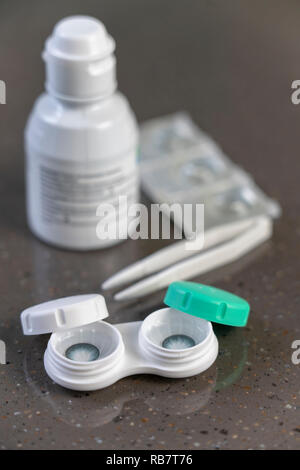 Container with green contact lenses on white background Stock Photo