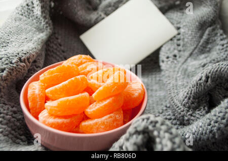 Slices of mandarine in pink bowl. Peeled tangerine. Stock Photo