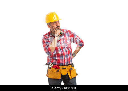Builder holding measuring tape and analyzing with focused expression touching chin with index finger isolated on white Stock Photo