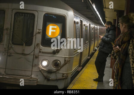 F train entering the subway station at 34th Street in Manhattan, New York City. Stock Photo