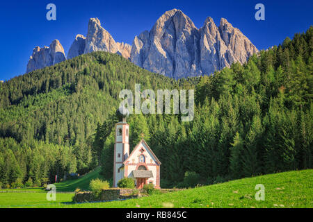 The church St. Johann in Ranui in the Villnoess / Funes valley in the Dolomites, South Tyrol, Italy. In the background the Geisler Group mountain rang Stock Photo