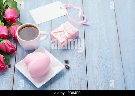 Valentine's Day greeting card or sale mockup with pink roses, gift box, heart shaped mousse cake and cookies. Stock Photo