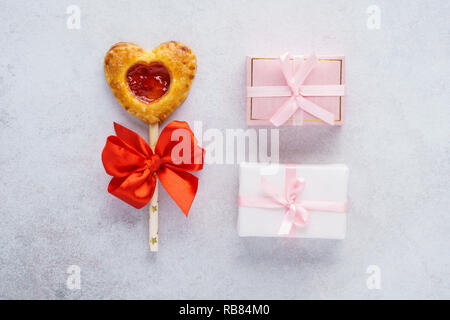 Strawberry pie pop on a stick decorated with red ribbon and two wrapped gift boxes. Valentines Day concept. Stock Photo