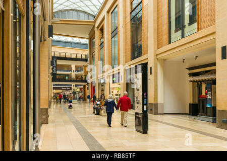 Interior of the Grand Arcade shopping centre with people walking past shop fronts, Cambridge, UK Stock Photo