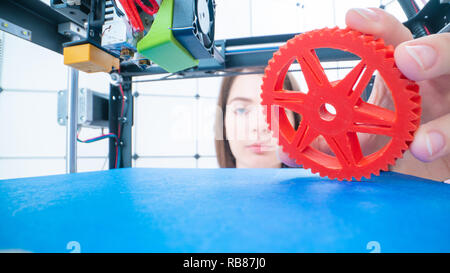 Young women designer in 3d printing lab. Girl takes the finished detail from 3D printer Stock Photo