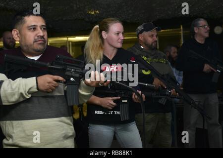 From left, Brian Garcia, MMAjunkie radio host, Valentina Shevchenko, UFC bantamweight fighter, Pavel Fedotov, Shevchenko’s coach, and Jacob Duran, professional cutman, operate Engagement Skills Trainer weapons during a visit to Joint Base Langley-Eustis, Va., Dec. 8, 2016. Shevchenko and UFC fighters Ben Rothwell, and Lorenz Larkin also met with U.S. Army Soldiers from the 7th Transportation Brigade (Expeditionary) and 690th Rapid Port Opening Element to discuss their different missions. Stock Photo