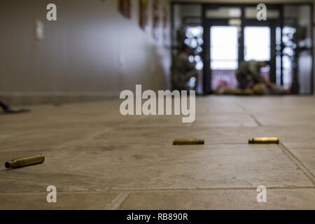 Bullet casings rest on the floor as members of the 23d Security Forces Squadron detain the simulated active shooter, Staff Sgt. Christopher Childress, 23d SFS military working dog trainer, during an active shooter exercise, Dec. 8, 2016, at Moody Air Force Base, Ga. This exercise caused included securing entrances to nearly every building on base. Stock Photo