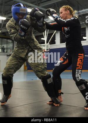 U.S. Air Force Airman 1st Class Ramon Crespo, 633rd Security Forces Squadron entry control point monitor, spars with Valentina Shevchenko, UFC Bantamweight fighter, at Joint Base Langley-Eustis, Va., Dec. 8, 2016. Schevchenko visited the installation along with UFC fighters, Ben Rothwell and Lorenz Larkin as well as MMAradio hosts and Jacob ‘Stitch’ Durand. Stock Photo