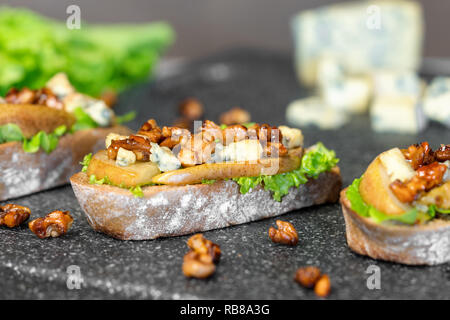 Snack bruschetta with pear, honey, walnut, cheese, green salad and olive oil Stock Photo