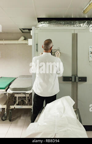 A dead body (corpse) is just arrived in the mortuary chamber in an hospital. Stock Photo