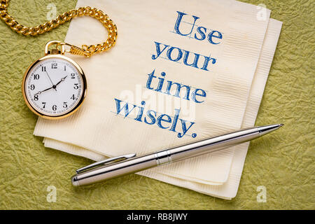 use you time wisely - inspirational handwriting on a napkin with a gold pocket watch Stock Photo