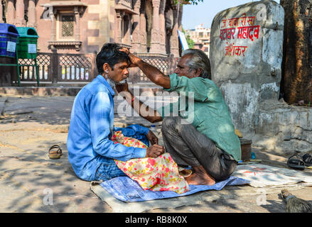 Jodhpur, India - Nov 6, 2017. A man gets a shave at a street barber shop in Jodhpur, India. Jodhpur is the second largest city in state of Rajasthan. Stock Photo