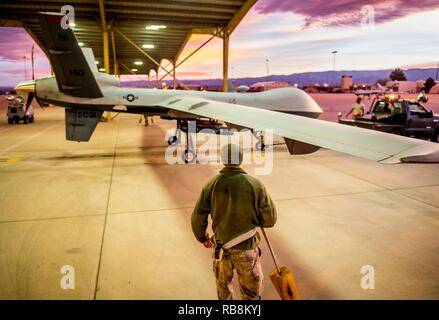 Airmen with the 49th Aircraft Maintenance Squadron tow an MQ-9 Reaper remotely piloted aircraft from the flightline at Holloman Air Force Base, N.M., Dec. 16, 2016. The squadron supports the 6th Reconnaissance Squadron as well as the 9th and 29th Attack Squadrons, enabling the graduation of pilots and sensor operators in support of the Air Force's largest formal training unit. Stock Photo