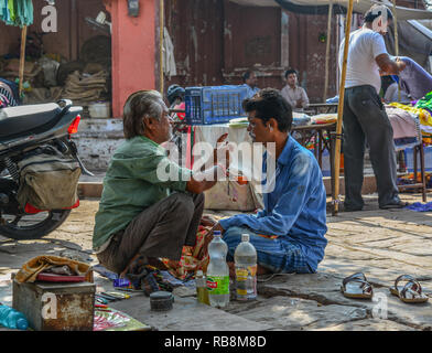 Jodhpur, India - Nov 6, 2017. A man gets a shave at a street barber shop in Jodhpur, India. Jodhpur is the second largest city in state of Rajasthan. Stock Photo