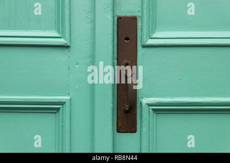 Rusted doorknob at the entry of a church - on a green door Stock Photo
