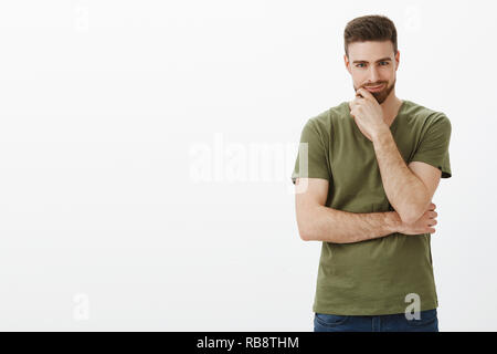 Guy having excellent plan, scheming something big and evil, smirking like genius and rubbing beard looking at camera, having something nasty in mind, posing delighted over white background Stock Photo