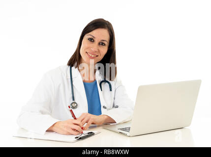 Portrait of happy woman doctor working on paperwork, writting patient records and using laptop computer searching online information isolated on white Stock Photo