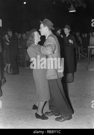 Dancing in the 1940s. A young couple at a dance holding each other close moving to the music. He is dressed in the typical Zoot suit, a men's suit with high-waisted, wide-legged trousers and a long coat with wide lapels and wide padded shoulders.   Photo Kristoffersson Ref 202-17. Stockholm Sweden 1941. Stock Photo