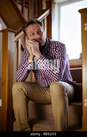 Man sat on stairs thoughtful Stock Photo