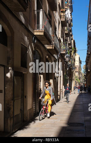 Barcelona, Spain - March 28, 2018: Unidentified woman riding bicycle on the streets of Barcelona. Bicycle as urban transport in Barcelona Stock Photo