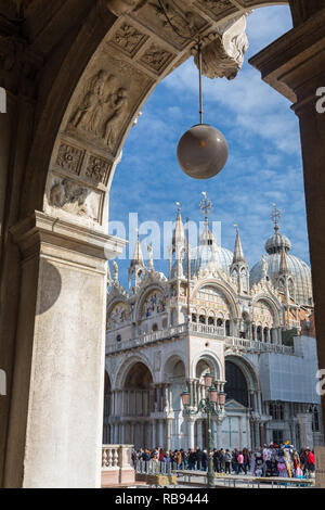 Venice, Italy - March 21, 2018: Tourists at San Marco square at sunny spring day in Venice, Italy. Basilica di San Marco view through the arch Stock Photo