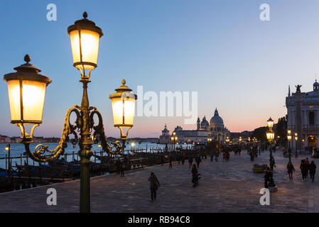 Venice , Italy - March 22, 2018: Old lanterns on the San Marco square with Santa Maria della Salute at background  at twilight in Venice , Italy Stock Photo