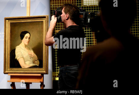 Berlin, Germany. 08th Jan, 2019. Journalists film the picture 'Portrait of a seated young woman/Portrait de jeune femme assise' by the artist Thomas Couture. The painting from the Gurlitt art find was identified as Nazi looted art and returned to the descendants. Credit: Britta Pedersen/dpa-Zentralbild/dpa/Alamy Live News Stock Photo
