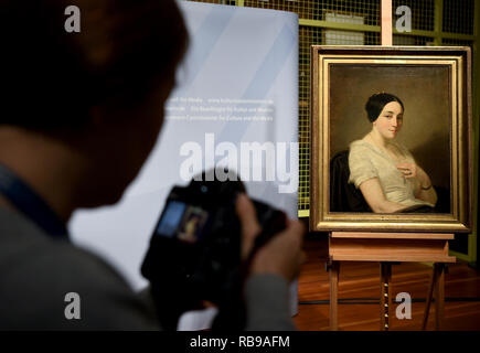 Berlin, Germany. 08th Jan, 2019. A photographer photographs the picture 'Portrait of a seated young woman/Portrait de jeune femme assise' by the artist Thomas Couture. The painting from the Gurlitt art find was identified as Nazi looted art and returned to the descendants. Credit: Britta Pedersen/dpa-Zentralbild/dpa/Alamy Live News Stock Photo