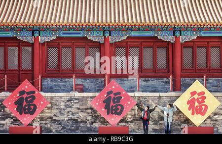 (190108) -- BEIJING, Jan. 8, 2019 (Xinhua) -- Visitors pose with Chinese character 'Fu', which means good luck at the Palace Museum, also known as the Forbidden City, in Beijing, capital of China, Jan. 8, 2019. The Palace Museum presents exhibition of 'Celebrating the Spring Festival in the Forbidden City' to greet the most important of all traditional holidays. The exhibition opened to the public on Tuesday. Hundreds of exhibits are displayed at the museum. (Xinhua/Li Xin) Stock Photo