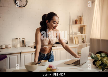 Young woman in lace bralette posing with golden palm leaf in her hand and  looking at camera Stock Photo - Alamy