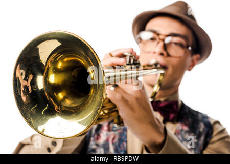 selective focus of mixed race male musician in stylish hat and eyeglasses playing on trumpet isolated on white Stock Photo