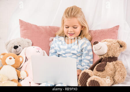 adorable child watching cartoons in bed Stock Photo