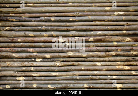 Old fence made from tree branches. Wall of twigs as background or texture. Stock Photo