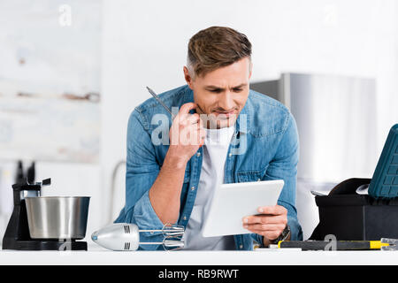 handsome man holding screwdriver and digital tablet Stock Photo