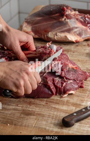 Butcher preparing venison meat at the Gog Farm Shop, Stapleford, Cambridge, Cambridgeshire Stock Photo