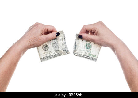 old wrinkled female hands tear one hundred dollars isolated on white background Stock Photo