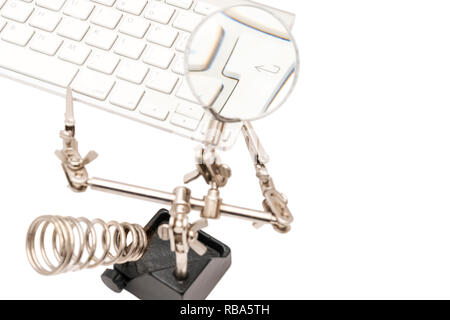white keyboard with enter key magnified through magnifying glass isolated on white background Stock Photo