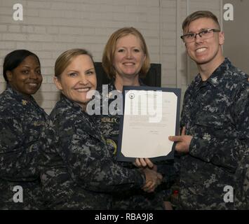 NEWPORT NEWS, Va. (Jan. 04, 2017) – Culinary Specialist 3rd Class Matthew Poole, assigned to Pre-Commissioning Unit Gerald R. Ford (CVN 78), receives his frocking letter from Cmdr. Julie Treanor, Ford’s supply officer, and Ford’s command master chief Laura Nunley during a supply department frocking ceremony at Apprenticeship Hall.  More than 170 Ford Sailors advanced from the September Navy-wide advancement exam. Stock Photo