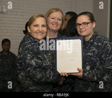 NEWPORT NEWS, Va. (Jan. 04, 2017) – Culinary Specialist 2rd Class Konely Cannalte, assigned to Pre-Commissioning Unit Gerald R. Ford (CVN 78), receives his frocking letter from Cmdr. Julie Treanor, Ford’s supply officer, and Ford’s command master chief Laura Nunley during a supply department frocking ceremony at Apprenticeship Hall.  More than 170 Ford Sailors advanced from the September Navy-wide advancement exam. Stock Photo