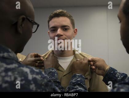 NEWPORT NEWS, Va. (Jan. 6, 2017) – Quartermaster 3rd Class Maxwell Clyburn, assigned to Pre-Commissioning Unit Gerald R. Ford (CVN 78), is frocked to the rank of petty officer third class by Chief Quartermaster Tyrone Anthony and Quartermaster 2nd Class Christian Rogers during a frocking ceremony. More than 170 Ford Sailors advanced from the September Navywide advancement exam. Stock Photo