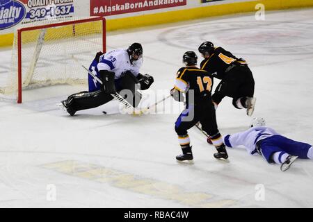 Cpl. Evan Hammersley, from Lynnfield, Mass., slides a shot under Air Force Goalie Senior Airman Stanislav Barilov in the third period of the 4th Annual Army vs. Air Force Hockey Game Jan. 7, 2017, at the Sullivan Arena in Anchorage, Alaska. The game is played annually between teams made up of service members assigned to Joint Base Elmendorf-Richardson, Alaska. Army's 5-0 shutout of the Air Force team tied the series at 2-2. Stock Photo