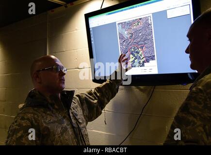Tech. Sgt. Daron, a member of the 236th Intelligence Support, shows an airmen a map of the wild fires in east Tennessee on Jan. 7, 2017 a Berry Field Air National Guard base in Nashville, TN. The 236th IS provided valuable imagery and mapping support to the Tennessee Emergency Management Agency and other civilian agencies fighting the fires. Air National Guard Stock Photo
